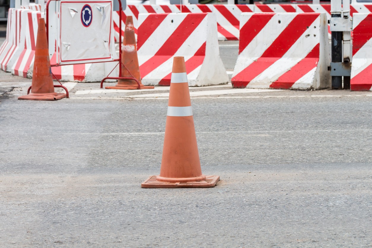 A traffic cone surrounded by traffic barriers for traffic safety.