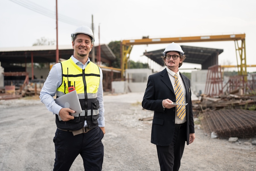 Portrait two caucasian engineer man working with notebook computer at precast site work