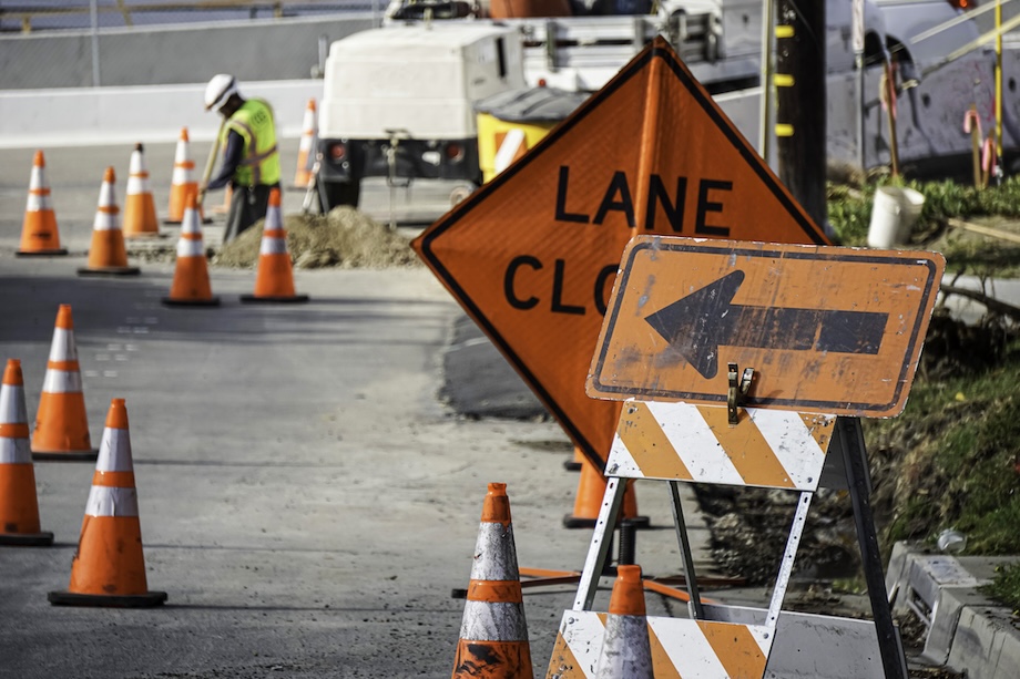 Road construction work being done with lanes closed sign