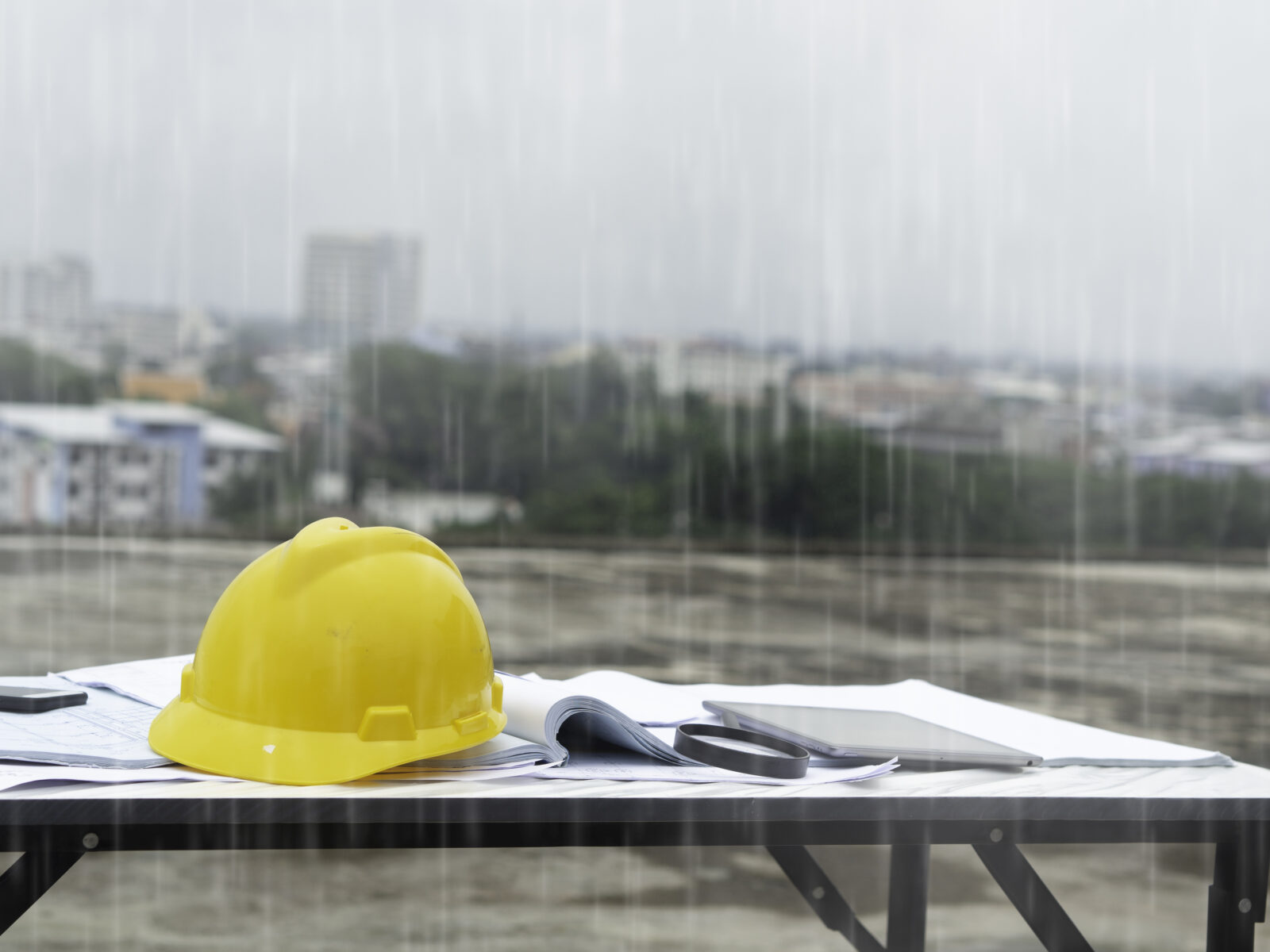 hard hat on a table of a construction site in the rain