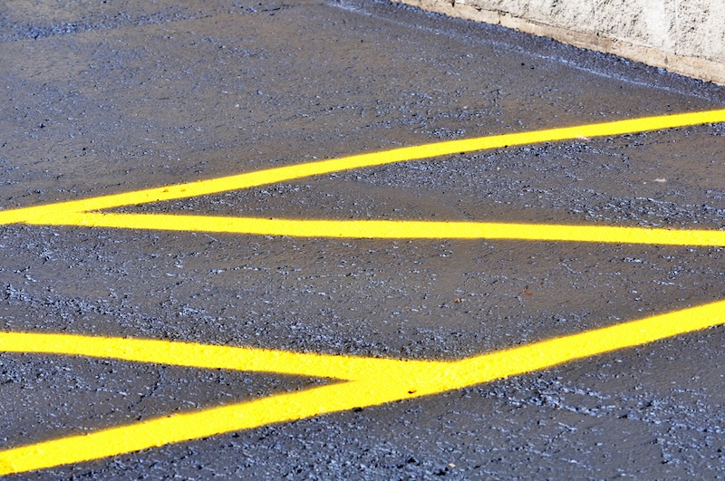 New asphalt with yellow striping in the parking lot.alt